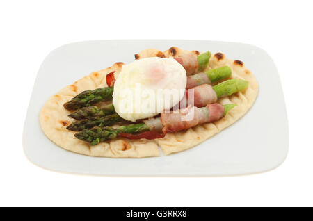 Pancetta avvolto asparagi con un uovo in camicia e flatbread su una piastra isolata contro bianco Foto Stock