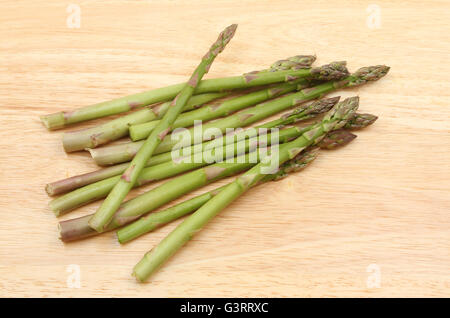 Gli asparagi spears su un tagliere di legno Foto Stock