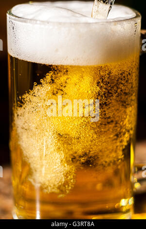 La birra o più grande che viene versato in un bicchiere Foto Stock