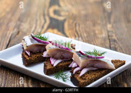 Antipasto cibo, aprire il panino con le aringhe e cipolla rossa Foto Stock