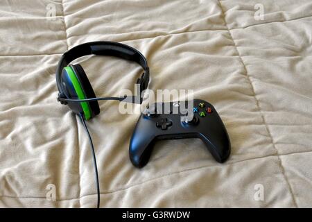 Un Xbox uno dei controller e le cuffie in posa su un letto Foto Stock