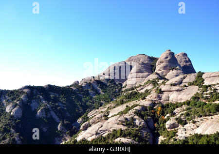 La montagna di Montserrat, la Catalogna, la Spagna e la piccola cappella di pietra di Sant Joan sul fianco della montagna Foto Stock