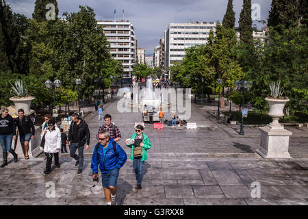 Le persone camminare intorno alla principale piazza Syntagma ad Atene, con la fontana in background. Foto Stock