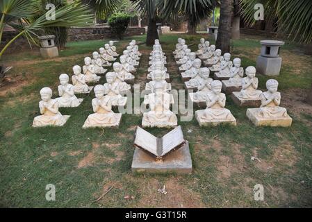 Statue di studenti seduti con la mano piegata in un parco a Nuova Delhi, India Foto Stock