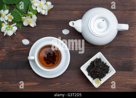 Teiera e tazza di tè al gelsomino su di un tavolo di legno Foto Stock