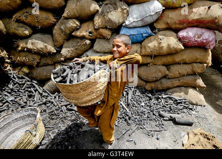 Di Karachi, Pakistan. 14 Giugno, 2016. Un figlio minorenne lavora al deposito di carbone per guadagnare la sua fonte di sostentamento per il supporto della sua famiglia, a Karachi il Martedì, 14 giugno 2016. Lavorando dal figlio minorenne durante il sole cocente è un punto interrogativo per i diritti del bambino i lavoratori. Credito: Asianet-Pakistan/Alamy Live News Foto Stock