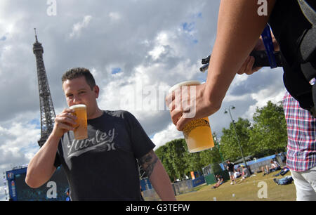 Parigi, Francia. Il 15 giugno, 2016. Un tifoso di calcio beve birra da una tazza di plastica mentre un fornitore serve una nuova birra in primo piano nella cordoned off fan zone sotto la Torre Eiffel al 2016 UEFA campionato europeo di Parigi (Francia), 15 giugno 2016. Foto: PETER KNEFFEL/dpa/Alamy Live News Foto Stock