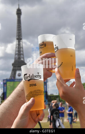 Parigi, Francia. Il 15 giugno, 2016. Gli appassionati di calcio toast con i loro bicchieri di plastica piena di birra nel cordoned off fan zone sotto la Torre Eiffel al 2016 UEFA campionato europeo di Parigi (Francia), 15 giugno 2016. Foto: PETER KNEFFEL/dpa/Alamy Live News Foto Stock