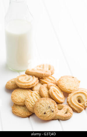 Dolce i biscotti al burro. Biscotti e latte in vaso sul tavolo bianco. Foto Stock