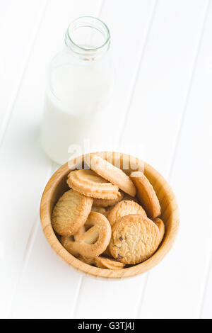 Dolce i biscotti al burro. I cookie nella ciotola e il latte nel vaso sul tavolo bianco. Foto Stock