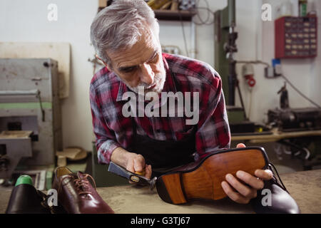 Il comando cobbler martellare sul tacco di una calzatura Foto Stock