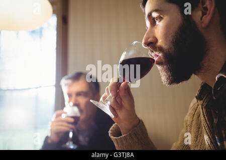 Ritratto di hipster e uomo maturo di bere vino rosso Foto Stock