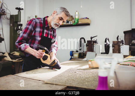 Il comando cobbler martellare sul tacco di una calzatura Foto Stock