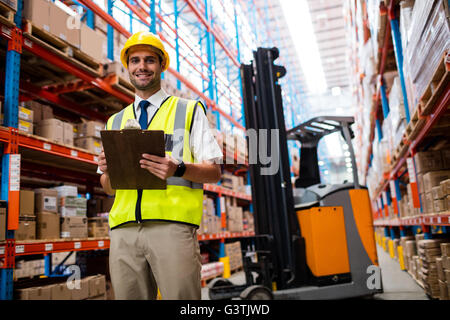 Sorridente warehouse manager con clipboard Foto Stock