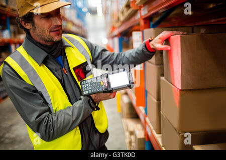 Lavoratore di magazzino tramite scanner a mano Foto Stock