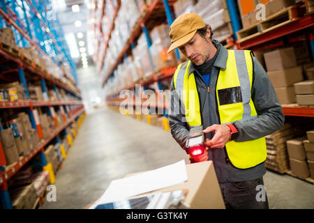 Lavoratore di magazzino tramite scanner a mano Foto Stock