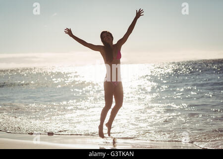 Giovane donna salto sulla spiaggia Foto Stock