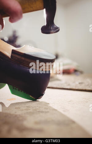 Stretta di mano il martellamento sul tacco di una calzatura Foto Stock
