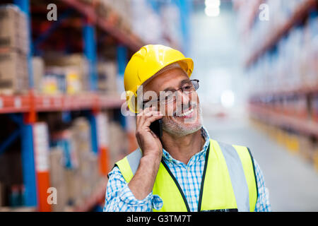 Lavoratore in hard hat usando il telefono cellulare Foto Stock