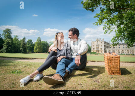 Gli amici sorseggiando un picnic sulle rive del fiume Cam in Cambridge. Foto Stock