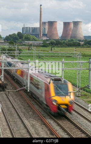 Una Vergine Voyager passa Rugeley power station su Trento sezione di valle della linea principale della costa occidentale. Foto Stock