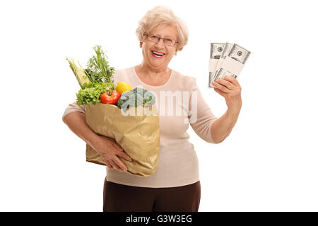 Coppia lady tenendo un sacco di negozi di generi alimentari e un paio di pile di denaro isolato su sfondo bianco Foto Stock