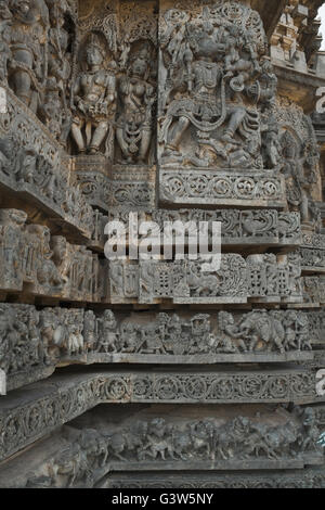 Ornati pannello parete rilievi raffiguranti divinità Indù, lato ovest, hoysaleshwara tempio, halebidu, Karnataka, India. Foto Stock