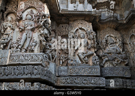 Scultura di bhairava sulla sinistra, Shiva nel centro, narsimha sulla destra, hoysaleshwara tempio, halebid, Karnataka, India Foto Stock