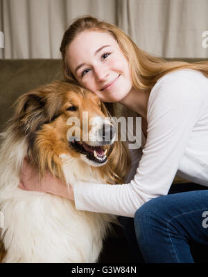 Ritratto di ragazza adolescente (14-15) abbracciando collie cane Foto Stock