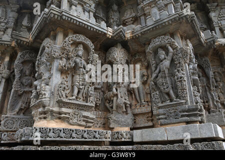 Pannello di parete bassorilievi raffiguranti (da sinistra) dea Lakshmi, divinità, un Sage, Krishna, Tempio Kedareshwara, Halebid, India Foto Stock