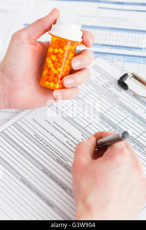 Medico azienda pillola bottiglia e documenti di riempimento Foto Stock