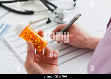 Medico azienda pillola bottiglia e documenti di riempimento Foto Stock