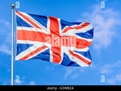 Union Jack flag del Regno Unito di Gran Bretagna e Irlanda del Nord, volare su un palo contro il cielo blu. Foto Stock