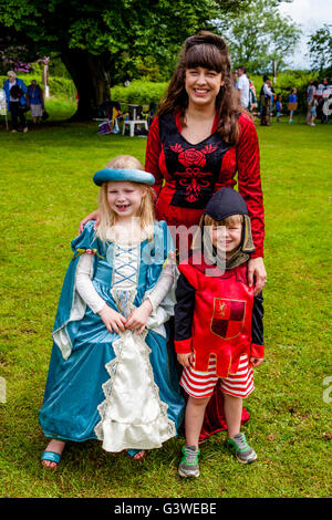 Una donna locale e i bambini vestiti in costume medievale presso la Fiera medievale di Abinger, Surrey, Regno Unito Foto Stock