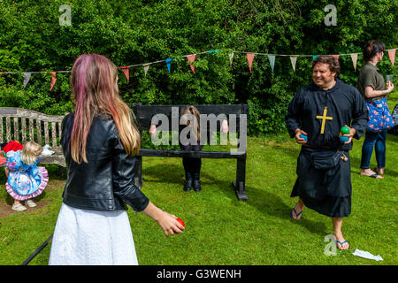 Una ragazza prepara acqua ToThrow bombe al suo amico che è in stock, la Fiera medievale di Abinger, Surrey, Regno Unito Foto Stock