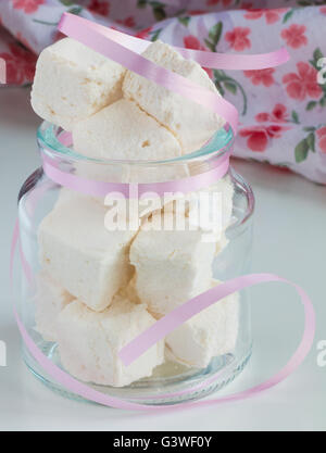 White marshmallows nel vasetto di vetro sul tavolo bianco Foto Stock