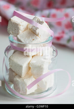White marshmallows nel vasetto di vetro sul tavolo bianco Foto Stock
