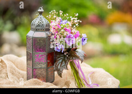 Giardino estivo stile bouquet. Mix di lilla e viola anemone fiori, fiori di geranio e heuchera alumroot o foglie. Bouquet Foto Stock