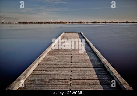 Lunga passerella di legno su un bellissimo lago Foto Stock