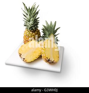 Ananassi sul tagliere isolato su bianco. Foto Stock