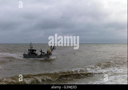 Piccola barca da pesca che entrano in terra in mare mosso, in Normandia, Francia Foto Stock