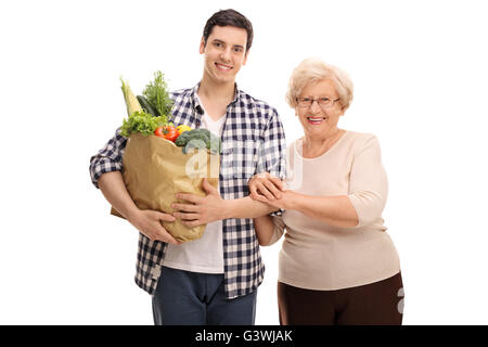 Nipote aiutando la sua nonna con i negozi di generi alimentari isolati su sfondo bianco Foto Stock