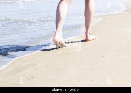 Unico uomo a camminare sulla spiaggia. Foto Stock