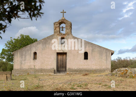 Vecchia chiesa rurale città abbandonate in Sardegna. Dettagli della croce e la campana. Foto Stock