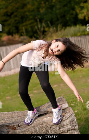 Le ragazze vogliono semplicemente divertirsi. Una giovane ragazza sta giocando boisterously, scaricarsi nel parco e divertirsi. Foto Stock