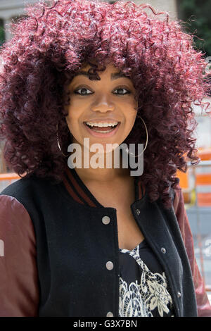 Ritratto di un bellissimo studente universitario con un più grande viola Afro taglio di capelli. Nel Greenwich Village di New York City. Foto Stock