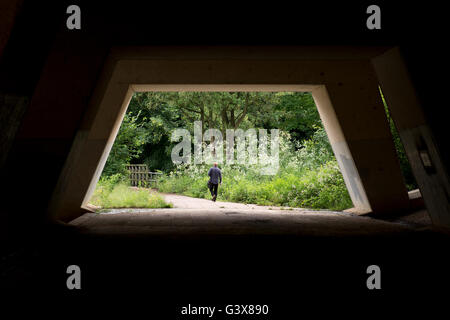 Uomo che cammina sotto l'autostrada M25, in Runnymede in Surrey UK Foto Stock