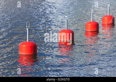 Red boe di ormeggio in una fila, marina europea attrezzature nautiche Foto Stock