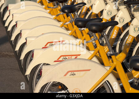 Parcheggiato giallo biciclette atm in una fila, Milano, Italia Foto Stock