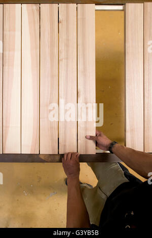 Un falegname di assemblaggio di una tabella con assi di legno in un workshop. Foto Stock